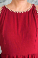 Red dress with decorative neckline against a blurred background