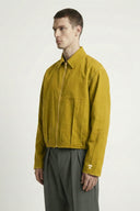 Man wearing a mustard yellow jacket on a white background