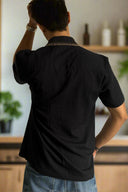 Person wearing a black shirt in a kitchen setting