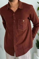 Brown shirt worn by a person on a plain background