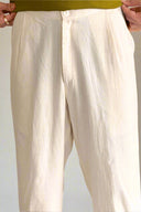 White pants being held up against a neutral background