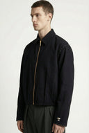 Man wearing a black jacket with a gold zipper on a white background