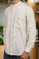 White long-sleeve shirt with decorative stitching on a neutral background
