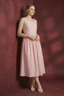 Woman wearing a pink dress against a red background