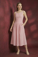 Woman wearing a pink dress against a red background