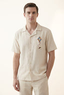 Man wearing a beige shirt with a geometric design on a white background