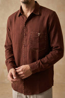 Brown button-up shirt worn by a person on a beige background