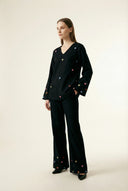 Woman wearing a black outfit with heart patterns on a white background